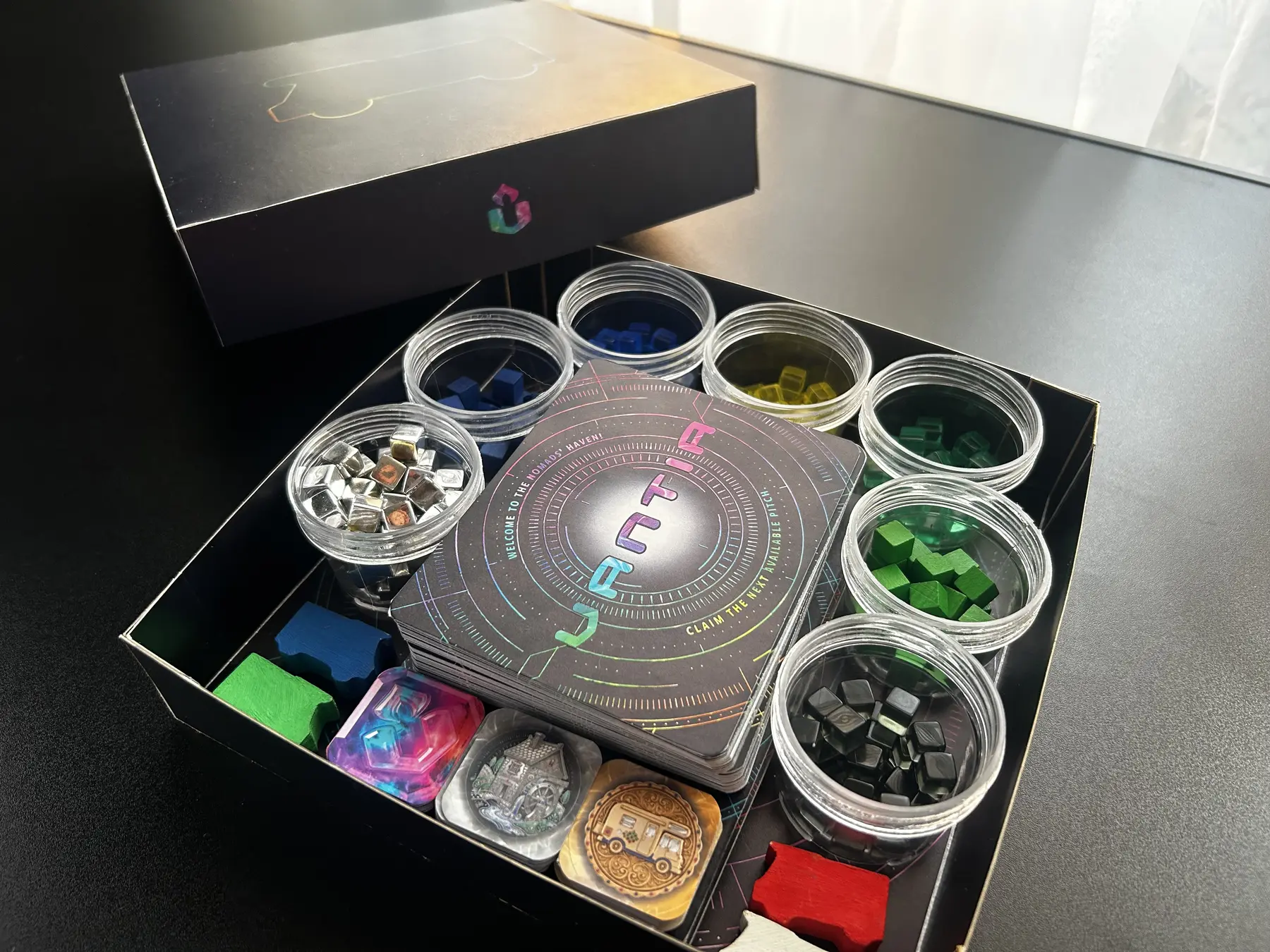 Early Nomads of Vantia prototypes with dashboards, wooden campervan pieces and resource cubes on a workshop table (1/3)